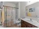 Well-lit bathroom with a shower-tub combo, decorative curtain and painting, and a large mirror at 185 Willow Valley Dr, Mooresville, NC 28115