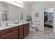 This bathroom features double sinks, wood cabinets, and shower with a neutral color palette creating a serene and functional space at 185 Willow Valley Dr, Mooresville, NC 28115