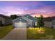 Charming single-Gathering home with well-manicured lawn and attached two car garage at dusk at 185 Willow Valley Dr, Mooresville, NC 28115