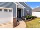 Home exterior featuring a covered entryway, attached garage, and manicured landscaping at 185 Willow Valley Dr, Mooresville, NC 28115
