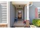 Covered front porch, brick detail, and charming seating arrangement enhance the entrance at 185 Willow Valley Dr, Mooresville, NC 28115