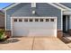 White garage door with decorative windows and blue siding, providing great curb appeal to the home at 185 Willow Valley Dr, Mooresville, NC 28115