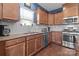 Well-lit kitchen boasts stainless steel appliances, granite countertops, and wood cabinets for a modern and functional design at 185 Willow Valley Dr, Mooresville, NC 28115