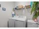 Functional laundry room with modern washer and dryer units and a shelf for supplies at 185 Willow Valley Dr, Mooresville, NC 28115