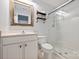 Bright bathroom features a glass shower, white vanity, and decorative mirror with convenient open shelving at 1925 Sandal Brook Rd, Indian Land, SC 29707