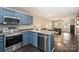 Stylish kitchen flows into the living area with stainless steel appliances and blue cabinetry at 1925 Sandal Brook Rd, Indian Land, SC 29707