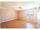 A spacious bedroom with hardwood floors, a ceiling fan, and a large window allowing natural light at 2031 36Th Ne St, Hickory, NC 28601