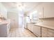Bright kitchen featuring white cabinetry, appliances, and tile flooring with an open doorway to the living room at 2031 36Th Ne St, Hickory, NC 28601