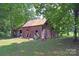 Vintage exterior of an outbuilding on a grassy lot surrounded by trees at 2131 E Nc 10 Hwy, Conover, NC 28613
