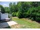 Serene backyard featuring a swing seat, lush greenery, and manicured lawn at 2180 Shady Pond Dr, Clover, SC 29710
