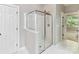 Bright bathroom featuring glass enclosed shower with showerhead, white tiling, and entry to bedroom area at 2215 Henery Tuckers Ct, Charlotte, NC 28270