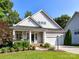 Charming home featuring a covered porch, attached garage, manicured landscaping and mature trees at 2215 Henery Tuckers Ct, Charlotte, NC 28270