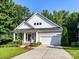 Charming home featuring a covered porch, attached garage, manicured landscaping and mature trees at 2215 Henery Tuckers Ct, Charlotte, NC 28270