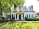 Charming home with a well-manicured lawn, dark green shutters, dormer windows and a covered front porch at 2215 Henery Tuckers Ct, Charlotte, NC 28270