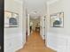 Hallway with hardwood floors, wainscoting, neutral walls, and decorative artwork at 2215 Henery Tuckers Ct, Charlotte, NC 28270