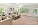 Bright living room with neutral color scheme, ceiling fan, and large windows at 2215 Henery Tuckers Ct, Charlotte, NC 28270
