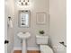 Stylish powder room with pedestal sink, framed mirror, and elegant fixtures at 2215 Henery Tuckers Ct, Charlotte, NC 28270