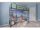 Blue bedroom featuring a bed lofted over a workspace with a desk and chair at 229 Cramerton Mills Pkwy, Cramerton, NC 28032