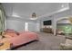 Bright and airy bedroom featuring a large bed, tray ceilings, and decorative furniture at 229 Cramerton Mills Pkwy, Cramerton, NC 28032