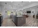 Open-concept kitchen island with barstools adjacent to the living room at 229 Cramerton Mills Pkwy, Cramerton, NC 28032