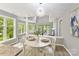 Bright dining area features a modern chandelier and many windows overlooking the lush greenery of the outdoors at 303 Northwest Dr, Davidson, NC 28036