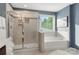 This bathroom features a glass enclosed shower, a luxurious soaking tub, and neutral tiling at 3212 Gilroy Dr, Fort Mill, SC 29707