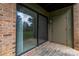 View of the patio through sliding glass doors with brick siding at 326 Orchard Trace Ln # 3, Charlotte, NC 28213