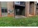 View of the patio with grass and brick siding at 326 Orchard Trace Ln # 3, Charlotte, NC 28213