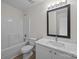 Bathroom with tub, toilet, and single sink vanity with framed mirror and overhead lighting at 3527 Crestridge Dr, Charlotte, NC 28217