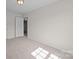 A minimalist bedroom features neutral carpet and a white door at 3527 Crestridge Dr, Charlotte, NC 28217