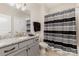 Bathroom vanity with gray cabinets, granite countertop and black and gray striped shower curtain at 4005 Capullo Ct, Matthews, NC 28104