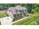 Aerial view of a luxurious brick home boasting a meticulously landscaped yard and long driveway at 4005 Capullo Ct, Matthews, NC 28104