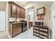 Small bar area with sink, cabinets, mini-fridge, microwave, and tile flooring at 4075 Crepe Ridge Dr, Denver, NC 28037