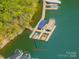 Aerial view of community boat slips and dock with covered boats on a serene lake at 4075 Crepe Ridge Dr, Denver, NC 28037