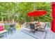 Outdoor deck area with a table, chairs, grill, and a red umbrella for shade at 4075 Crepe Ridge Dr, Denver, NC 28037
