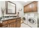 Functional laundry room with washer, dryer, storage cabinets, sink and granite countertops at 4075 Crepe Ridge Dr, Denver, NC 28037