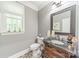 Charming powder room featuring a decorative mirror, vanity with granite countertop, and a stylish faucet at 4075 Crepe Ridge Dr, Denver, NC 28037