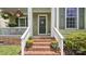Close-up of the home's entrance with brick steps, potted plants, and decorative door wreath at 4115 Birkshire Hts, Fort Mill, SC 29708
