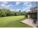 Expansive backyard with lush green grass, mature trees, and a wooden deck with stairs at 4201 Amber Leigh Way Dr, Charlotte, NC 28269