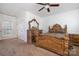 Bright bedroom features decorative wooden bed frame, dresser with mirror, and neutral carpet at 4201 Amber Leigh Way Dr, Charlotte, NC 28269
