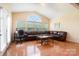 Bright living room with large windows, hardwood floors, and a comfortable leather sectional at 4201 Amber Leigh Way Dr, Charlotte, NC 28269