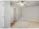 Neutral bedroom with a ceiling fan and carpeted floor. Open doorway reveals hardwood flooring in the adjacent room at 4410 Burgin St, Kannapolis, NC 28081