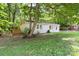 Quaint home with a small deck and a mix of brick and siding, nestled among mature trees and a lush green yard at 4410 Burgin St, Kannapolis, NC 28081