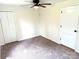 Carpeted bedroom featuring a ceiling fan, multiple closets and a standard door to create a cozy and functional space at 4421 Linwood Rd, Gastonia, NC 28052
