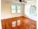 This bedroom features beautiful hardwood floors, large windows, and a ceiling fan to create a pleasant and inviting atmosphere at 4421 Linwood Rd, Gastonia, NC 28052