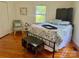 Bedroom with hardwood floors, a full-size bed, and natural light from the windows, creating a warm and inviting space at 4421 Linwood Rd, Gastonia, NC 28052