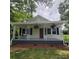 Charming home featuring a cozy front porch with a swing and hanging plants at 4421 Linwood Rd, Gastonia, NC 28052