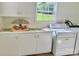 Bright laundry room featuring white cabinets, a window with a view, and a washing machine for convenient chores at 4421 Linwood Rd, Gastonia, NC 28052