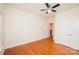 Bright bedroom features hardwood floors, a ceiling fan, closet doors, and an open doorway, adding functionality and style at 4518 Courtyard Blvd # 4, Harrisburg, NC 28075