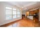 Bright dining area features wood floors, large window, and modern chandelier, seamlessly connecting to the kitchen and living spaces at 4518 Courtyard Blvd # 4, Harrisburg, NC 28075